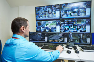 Man monitoring multiple computer screens